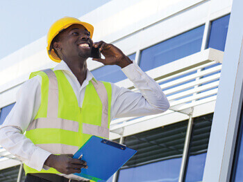 Maintenance Technician at a job site on a cell phone